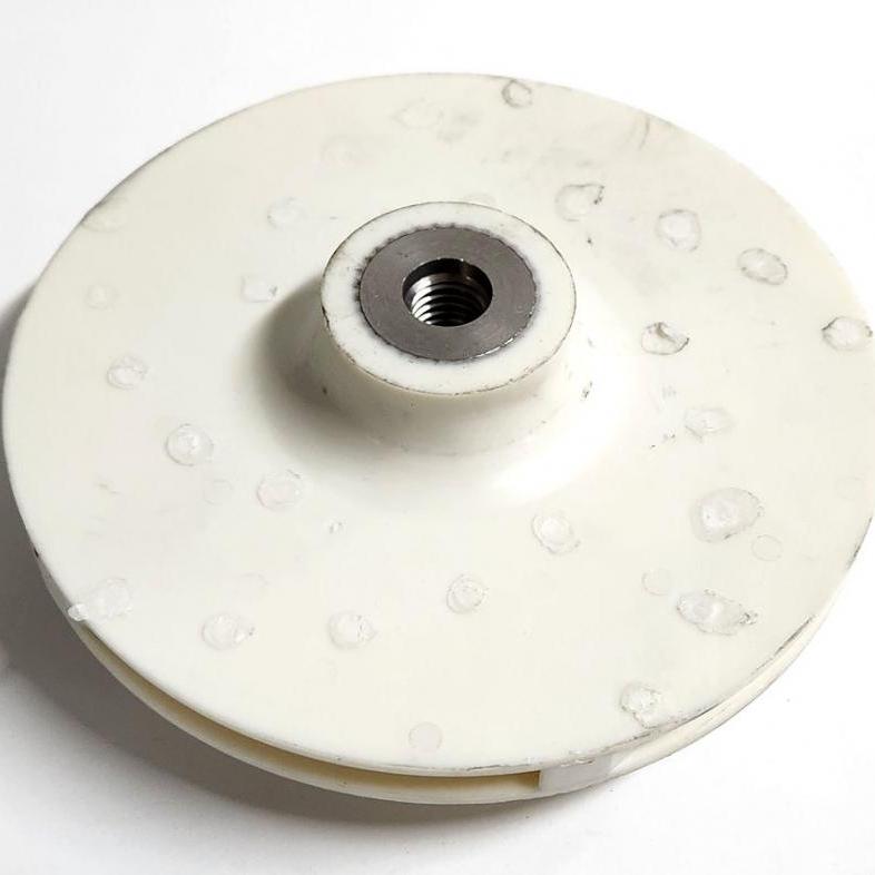 White Valox pump impeller with a circular plastic disc design and a threaded metal center hub.