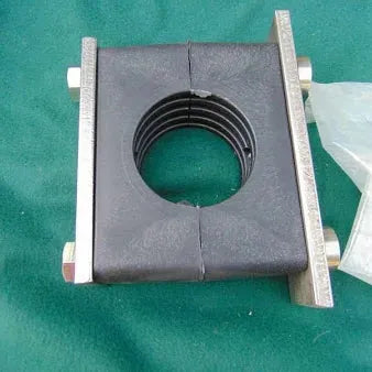 1-inch Behringer clamp with a black ribbed rubber block secured between two metal plates and bolts on a green background.