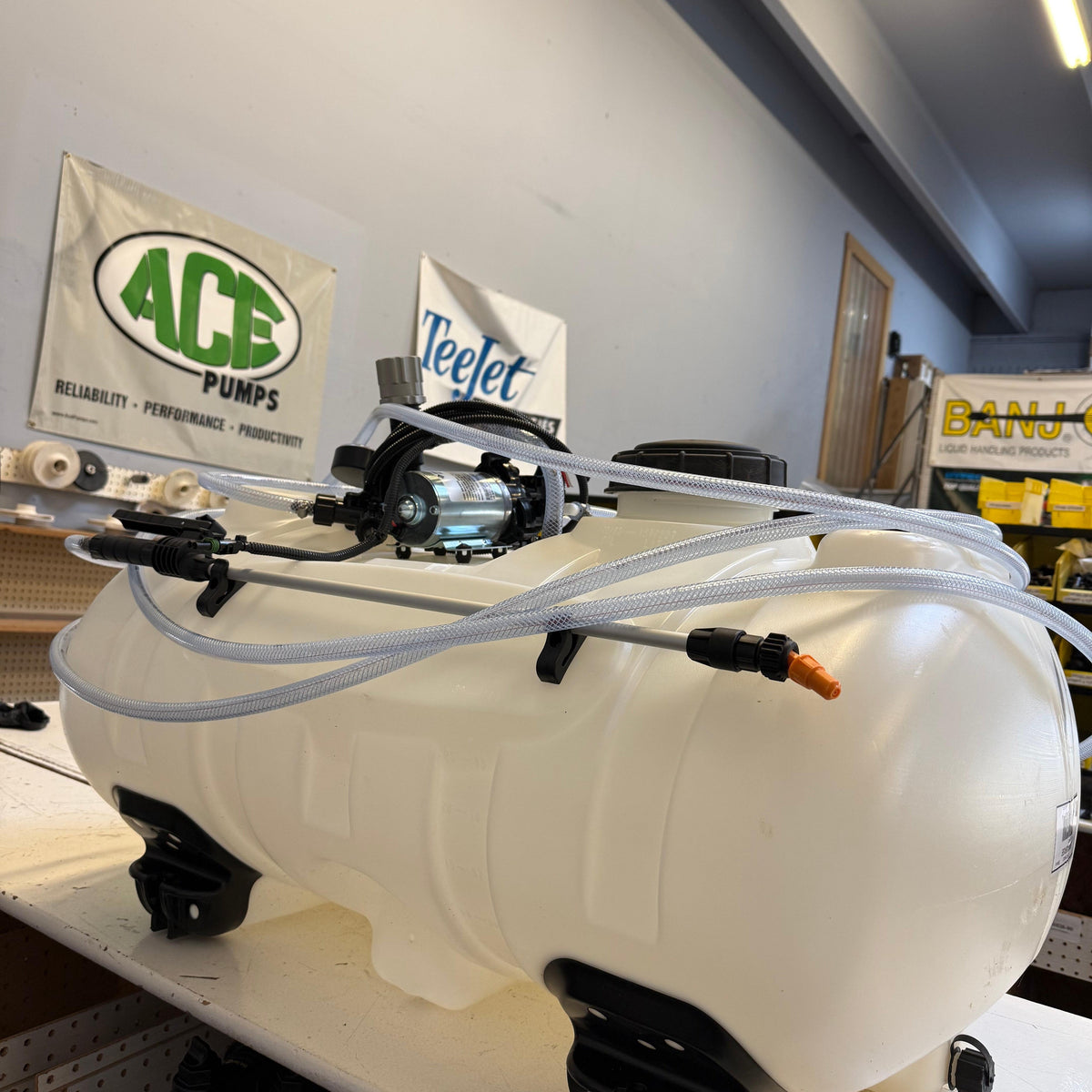 40-gallon white plastic ATV sprayer tank with a 3GPM pump, clear hoses, and a spray wand mounted on top.